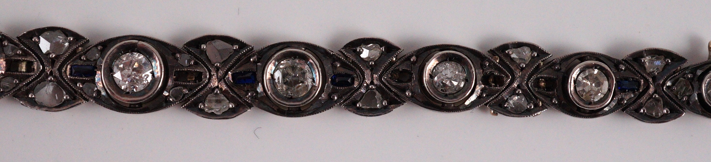 An early to mid 20th century continental gold and silver, graduated diamond and sapphire set line bracelet